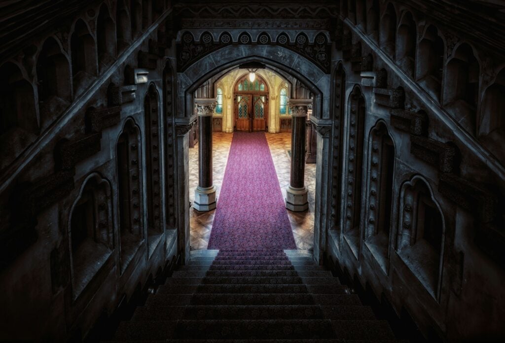 a hallway with a pink carpet and a doorway